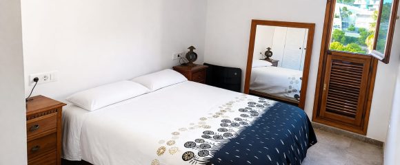 Dormitorio con ropa de cama limpia en un apartamento de alquiler vacacional en Calpe