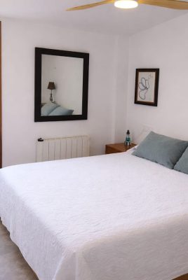 Dormitorio preparado tras la limpieza entre huéspedes, con cama vestida
